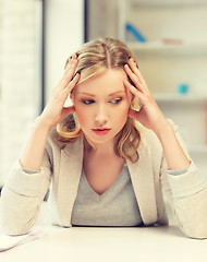 Image showing bored and tired woman behind the table