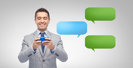 Image showing happy businessman texting message on smartphone