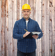 Image showing smiling male builder in helmet with clipboard