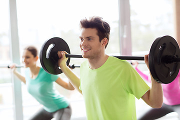 Image showing group of people exercising with barbell in gym