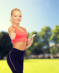 Image showing smiling sporty woman with smartphone