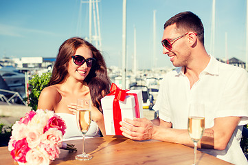 Image showing smiling couple with gift box cafe