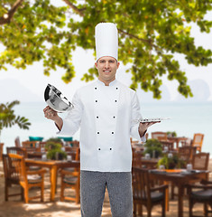 Image showing happy male chef cook opening cloche