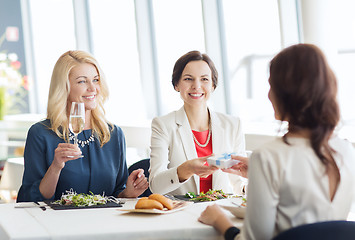Image showing happy women giving birthday present at restaurant