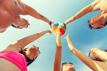 Image showing smiling friends in circle on summer beach