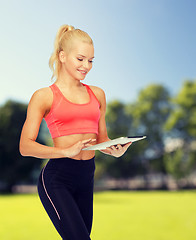 Image showing smiling sporty woman with tablet pc computer