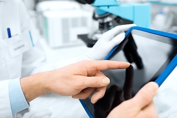 Image showing close up of scientists hands with tablet pc in lab