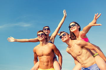 Image showing smiling friends having fun on summer beach