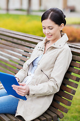 Image showing woman with tablet pc sitting on bench in park