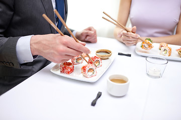 Image showing close up of couple eating sushi at restaurant