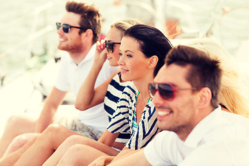 Image showing smiling friends sitting on yacht deck