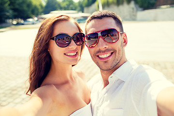 Image showing smiling couple wearing sunglasses making selfie