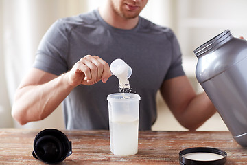 Image showing close up of man with protein shake bottle and jar