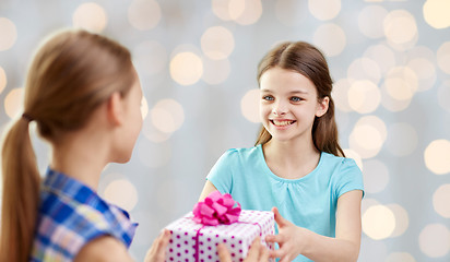 Image showing happy girls with birthday present over lights