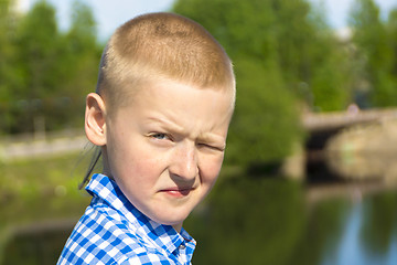 Image showing Ten year boy squints in the sun