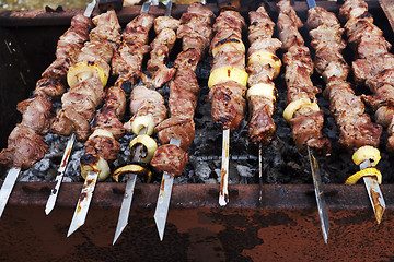 Image showing grilled meat on metal skewers cooking on a coal