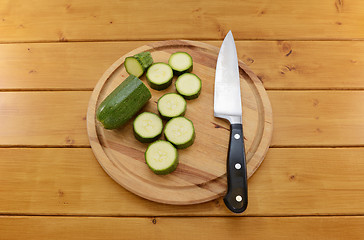 Image showing Courgette sliced with a knife on a chopping board
