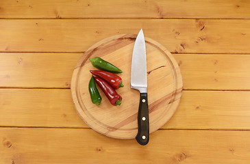 Image showing Red and green chilis with a knife on a chopping board