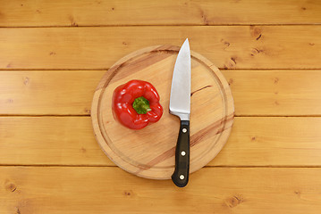 Image showing Red pepper with a knife on a chopping board