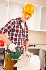 Image showing repairman works jigsaw