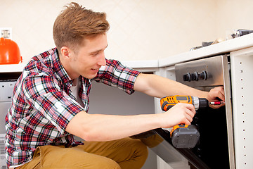 Image showing worker installs a electric cooker