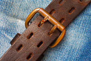 Image showing clasped leather belt on jeans background