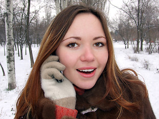Image showing The girl in the winter in park speaks by phone