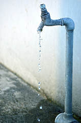 Image showing Tap of running water isolated on grey background