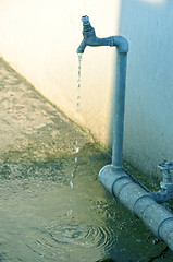 Image showing Tap of running water isolated on grey background