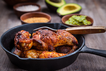 Image showing Grilled chicken legs and wings with guacamole