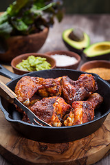 Image showing Grilled chicken legs and wings with guacamole