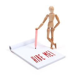 Image showing Wooden mannequin writing in scrapbook - Hire me