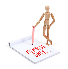 Image showing Wooden mannequin writing in scrapbook - Members only