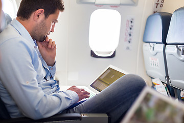 Image showing Businessman working with laptop on airplane.