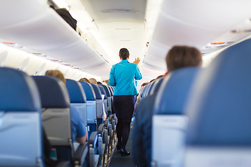 Image showing Interior of airplane with passengers on seats.