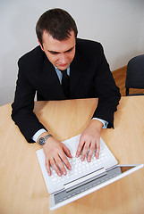 Image showing Businessman working on white laptop