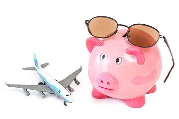 Image showing Piggy bank with sunglasses and toy plane