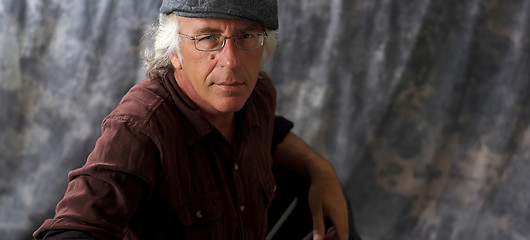 Image showing blue eyed man with glasses and grey hair wearing cap