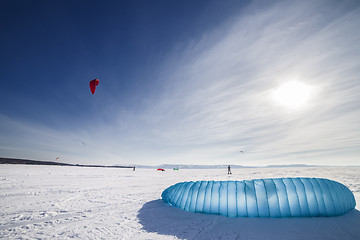 Image showing Kiteboarder with blue kite on the snow