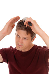 Image showing Man brushing his hair.