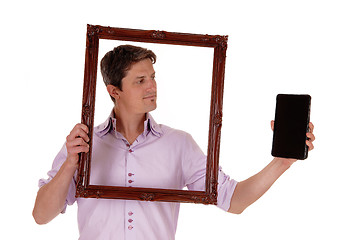 Image showing Man looking trough picture frame.