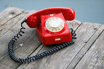 Image showing Red phone on wooden deck