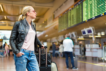 Image showing Female traveller checking flight departures board.