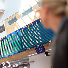 Image showing Female traveller checking flight departures board.