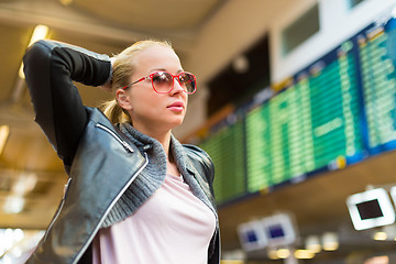 Image showing Female traveller checking flight departures board.