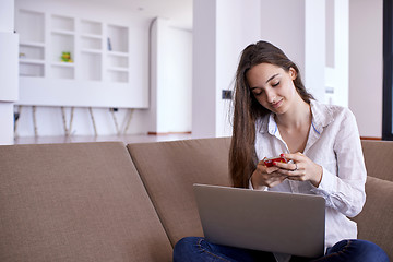 Image showing relaxed young woman at home working on laptop computer