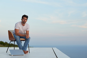 Image showing relaxed young man at home on balcony