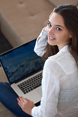 Image showing relaxed young woman at home working on laptop computer