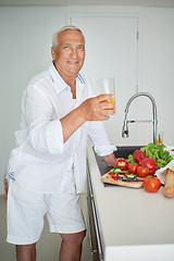 Image showing man cooking at home preparing salad in kitchen