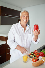 Image showing man cooking at home preparing salad in kitchen